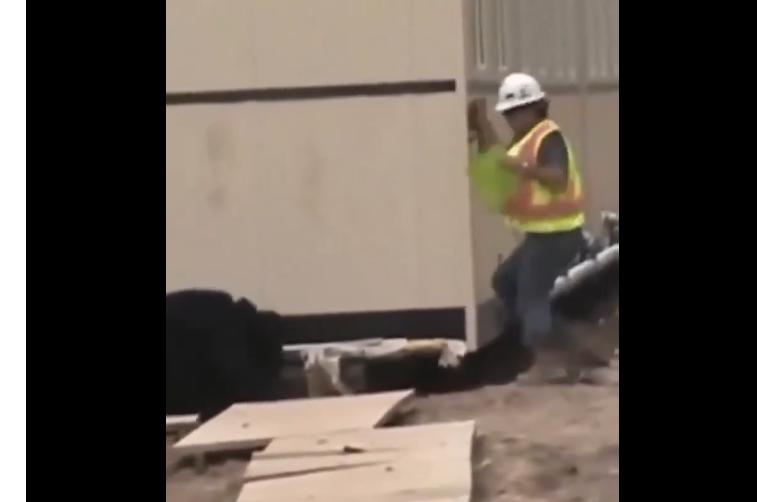 Construction worker at the corner of the outside of a building